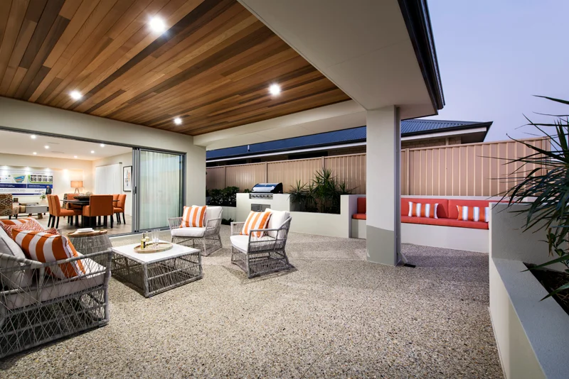 Covered modern patio with wicker seating, barbecue and striped cushions
