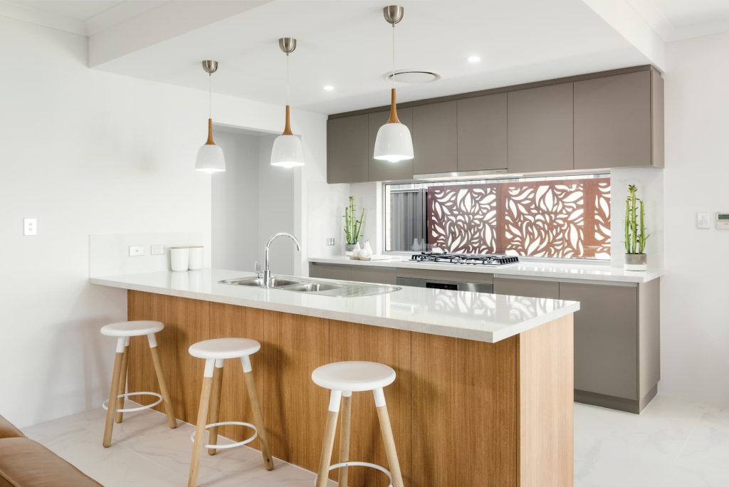 Modern kitchen with timber island, white stools and pendant lights