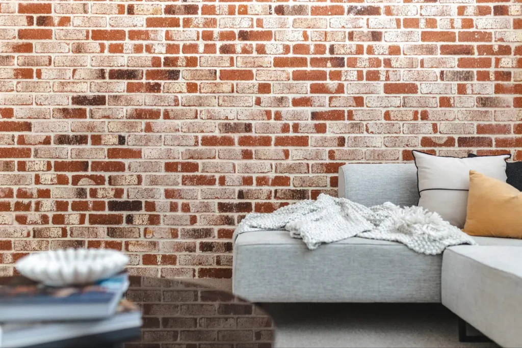 Living room with a feature brick wall and a light grey sofa in a Perth family home