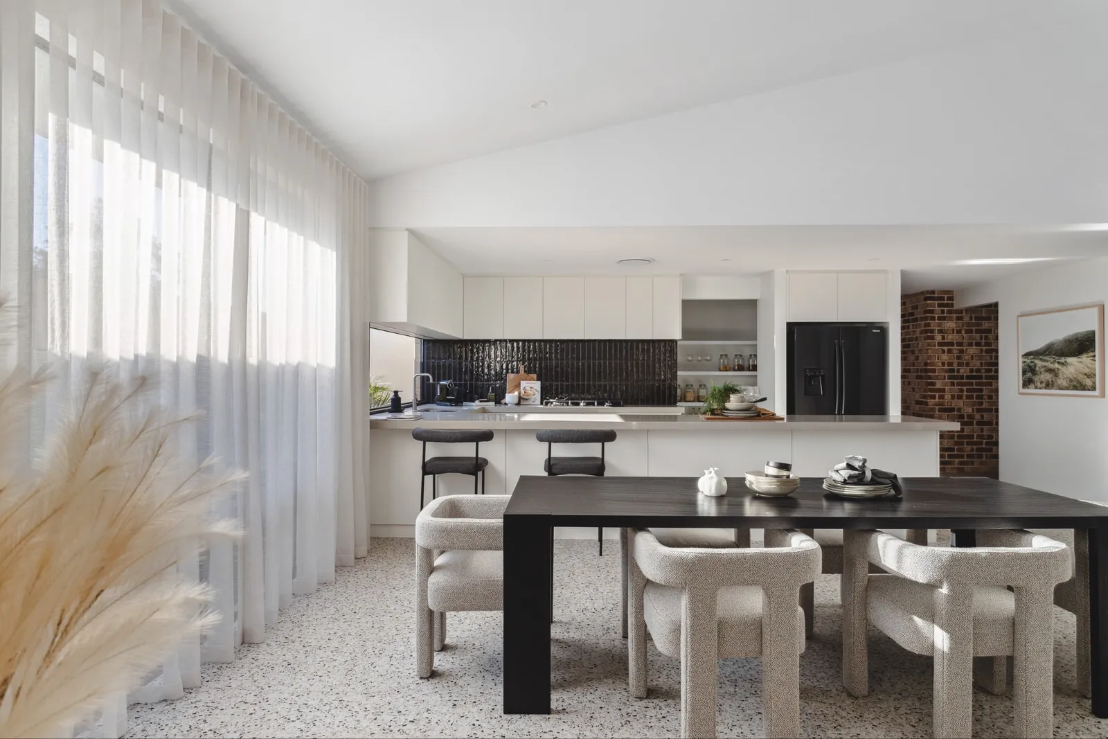 Open-plan kitchen and dining area with sheer curtains filtering natural light in a Perth home