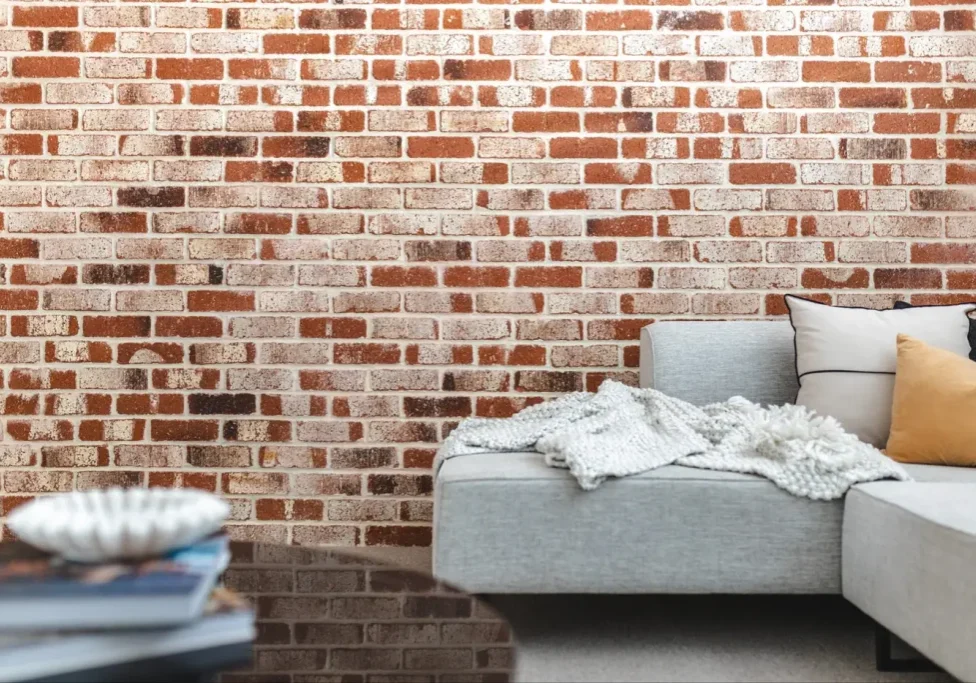 Living room with a feature brick wall and a light grey sofa in a Perth family home